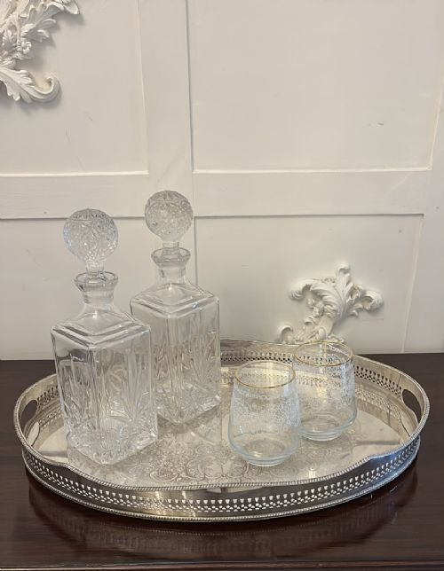 An oval Edwardian silver plated serving tray with an engraved foliate surface pattern and a pierced gallery border featuring cut-out hand grips. View V