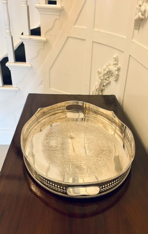 An oval Edwardian silver plated serving tray with an engraved foliate surface pattern and a pierced gallery border featuring cut-out hand grips. View XI