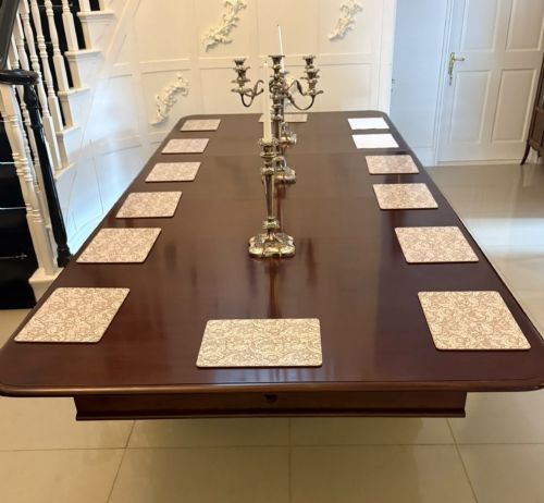 fig 1. A large William IV figured mahogany extending dining table with a polished surface, rounded corners, and turned legs on brass castors.