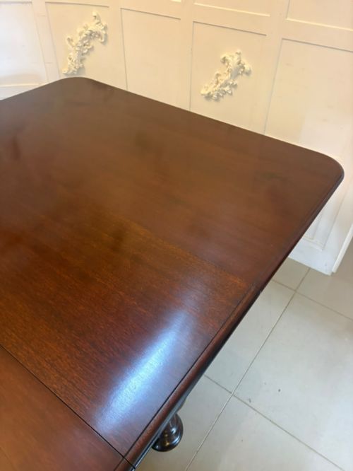 fig 4. A large William IV figured mahogany extending dining table with a polished surface, rounded corners, and turned legs on brass castors.