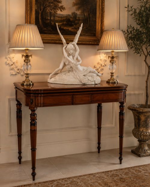 fig 2. An antique Georgian mahogany fold-over card table featuring turned legs and subtle inlay stringing.