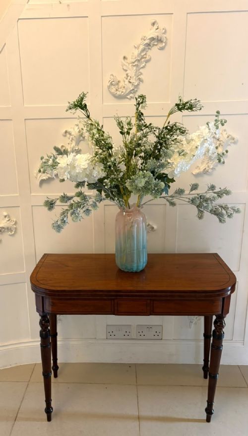 fig 3. An antique Georgian mahogany fold-over card table featuring turned legs and subtle inlay stringing.
