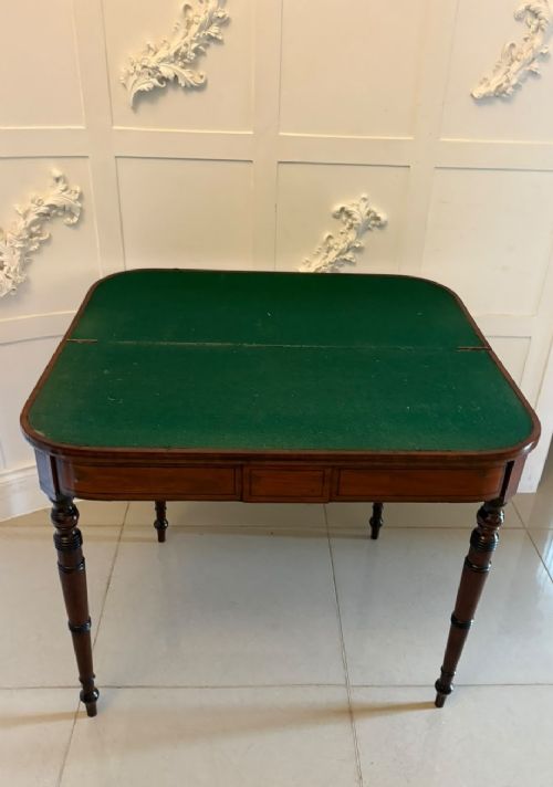 An antique Georgian mahogany fold-over card table featuring turned legs and subtle inlay stringing. View V