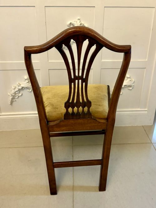 fig 2. A set of twelve mahogany Hepplewhite style dining chairs featuring shield backs with carved splats and gold velvet drop-in seats.
