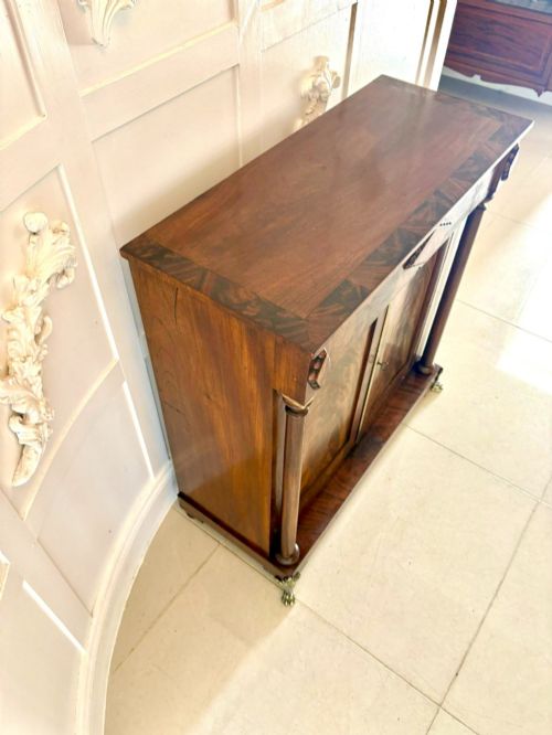 fig 2. An antique Regency mahogany chiffonier cabinet featuring flame mahogany double doors, turned side columns, diamond detailing, and metal claw feet.
