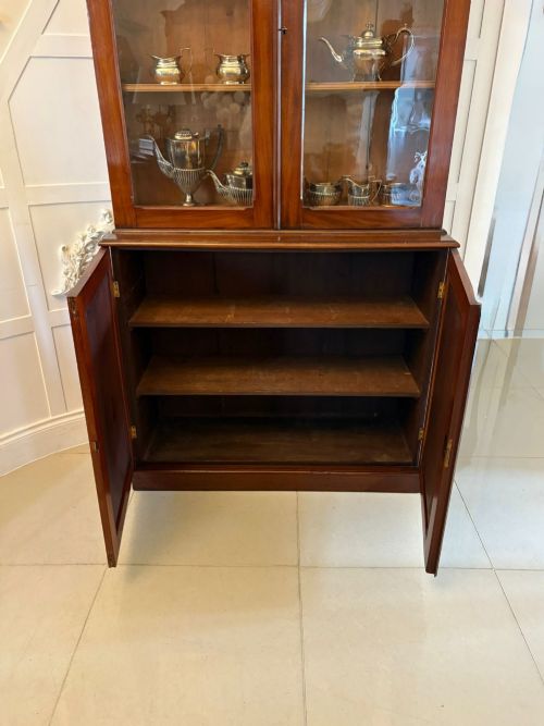 fig 1. An antique Victorian mahogany bookcase featuring two upper glass-glazed doors and two lower flame mahogany panelled cupboard doors.