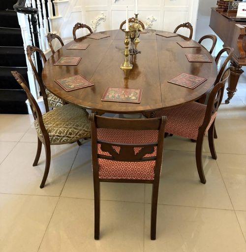 fig 1. A large oval figured walnut wake dining table featuring drop leaves and cabriole legs ending in pad feet.