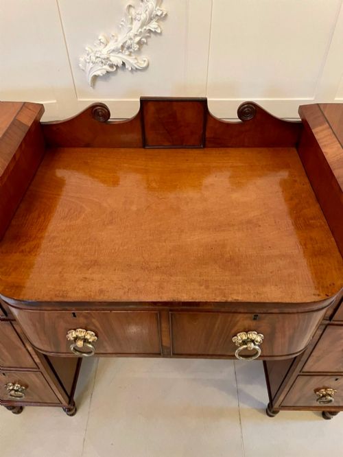 fig 1. An antique Regency mahogany secretaire sideboard featuring twin pedestals, multiple drawers with brass ring pulls, and a scrolled backboard gallery.