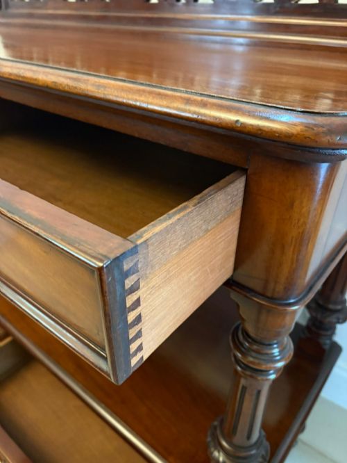 fig 4. A Victorian mahogany buffet server featuring an openwork carved gallery back, four drawer compartments, turned columns, and an open lower shelf.