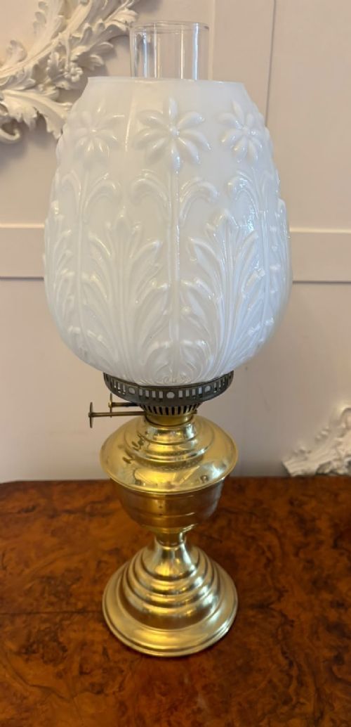 A near pair of Edwardian brass oil lamps featuring moulded white opaline glass shades and clear glass chimneys. View IX
