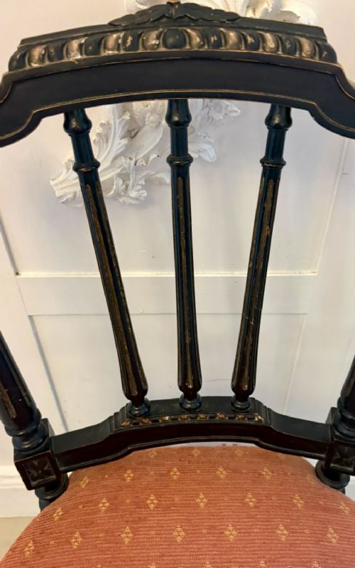 A set of four antique Victorian side chairs featuring ebonised black frames with turned spindle backrests, gilt details, turned front legs, and terracotta patterned upholstered seats. View VI