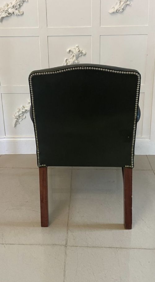 A pair of dark green leather armchairs with polished mahogany frames and brass stud detailing along the upholstery edges. View II