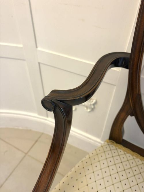 fig 4. A set of ten antique Edwardian mahogany dining chairs featuring carved shield-shaped backrests and light cream upholstered seats.