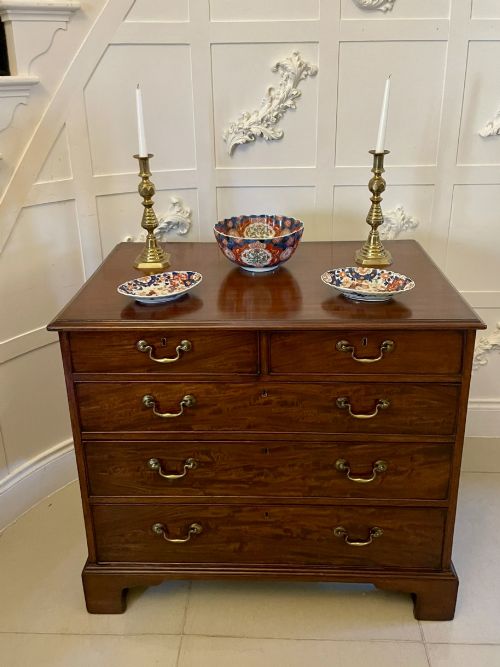 fig 1. A George III mahogany chest of drawers featuring a two-over-three drawer configuration with brass swan-neck handles on bracket feet.