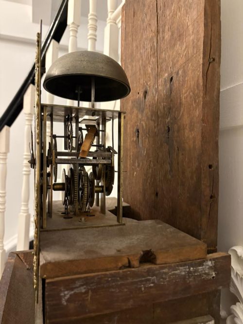fig 1. A George III oak and burr oak longcase clock featuring a square brass dial, fretwork hood frieze, and a long waist door.