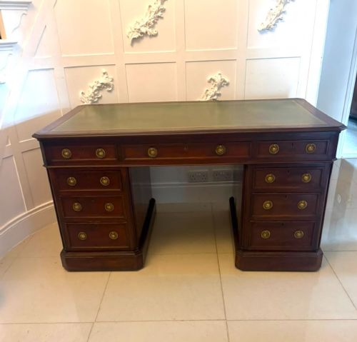 fig 1. A Victorian mahogany pedestal desk featuring a green leather inset writing surface, brass ring handles, and two drawer pedestals framing a central kneehole.