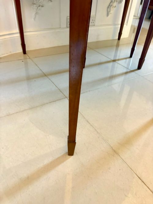fig 1. A pair of antique George III semi-circular mahogany console tables with smooth figured tops, apron friezes, and slender tapered legs.