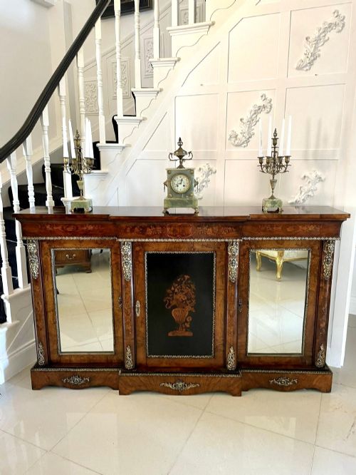 fig 3. A Victorian burr walnut breakfront credenza featuring brass mounts, a central floral marquetry panel, and mirrored side doors.