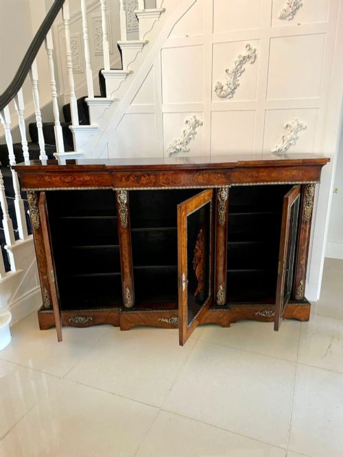 fig 4. A Victorian burr walnut breakfront credenza featuring brass mounts, a central floral marquetry panel, and mirrored side doors.