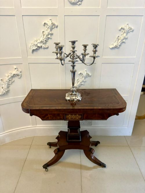 fig 2. An antique Regency mahogany fold-over card table featuring brass marquetry inlay, a central shaped pedestal, and a splayed base with brass castors.