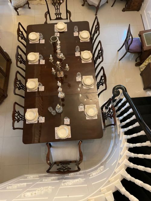fig 3. A large polished Georgian mahogany three-pedestal dining table supported by turned columns and splayed legs with brass castors.