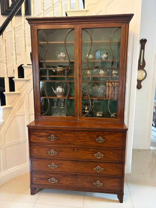 fig 1. An antique Regency mahogany secretaire bookcase with glazed upper doors featuring curved astragal glazing, resting on a base with four drawers and brass hardware.