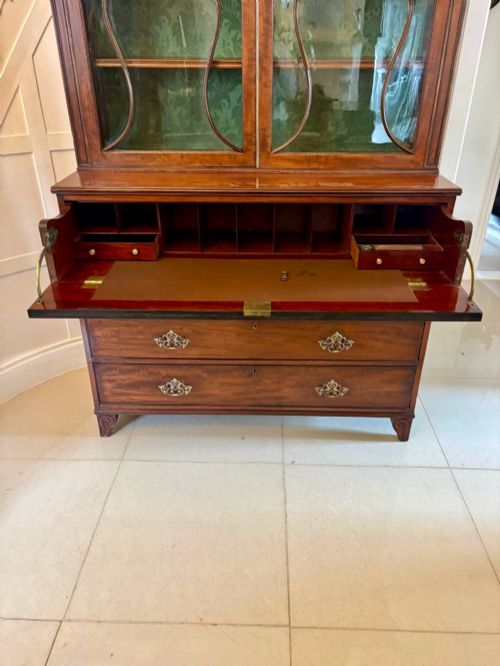fig 2. An antique Regency mahogany secretaire bookcase with glazed upper doors featuring curved astragal glazing, resting on a base with four drawers and brass hardware.