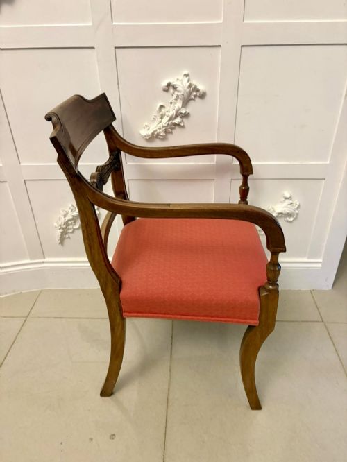 fig 5. A set of twelve Regency mahogany dining chairs featuring tablet top back rails, carved crossbars, and terracotta fabric upholstered seats, including two carvers with curved armrests.