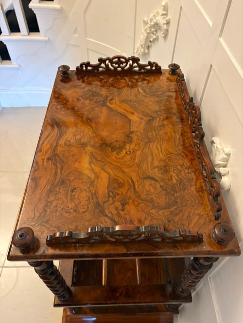 fig 1. A Victorian burr walnut Canterbury featuring a top surface with a pierced fretwork gallery, barley twist supports, divided slots, and a single drawer resting on porcelain castors.