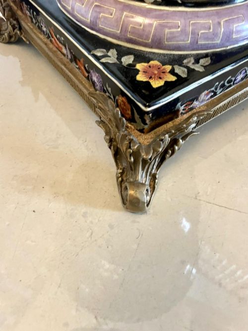 fig 4. A pair of black French porcelain jardiniere urns featuring polychrome floral enamel, central painted animal reserves, and gadrooned brass mounts on square plinths.