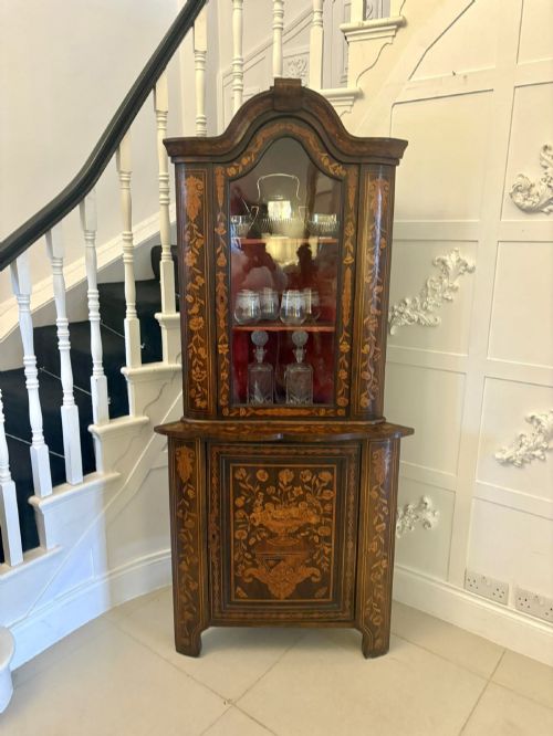 fig 2. A 19th-century two-tier Dutch marquetry corner cabinet featuring intricate floral inlays, an arched glazed top door, and a solid lower cupboard door.