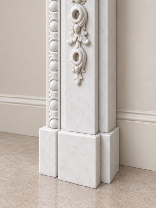 fig 2. A pair of carved white marble Edwardian fireplace surrounds featuring fruit swags, ribbon bow motifs, and scrolled side brackets.