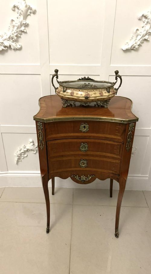 An antique French Louis XV style wooden side cabinet featuring three marquetry drawers, brass rim, decorative corner mounts, and slender cabriole legs. View VII