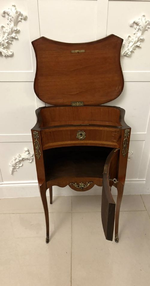 An antique French Louis XV style wooden side cabinet featuring three marquetry drawers, brass rim, decorative corner mounts, and slender cabriole legs. View VIII