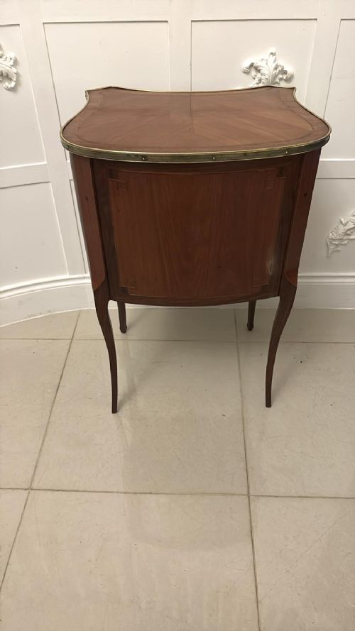 An antique French Louis XV style wooden side cabinet featuring three marquetry drawers, brass rim, decorative corner mounts, and slender cabriole legs. View IX