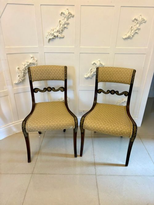 fig 1. A set of eight antique Regency mahogany dining chairs featuring patterned gold upholstery, carved scrolling mid-rails, and brass detailing.