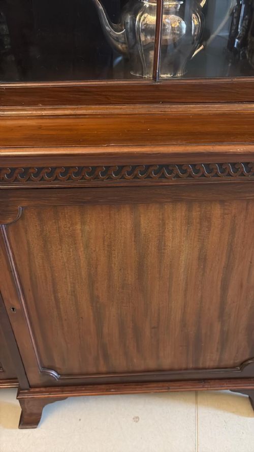 fig 2. An antique Edwardian mahogany breakfront bookcase featuring three glazed upper doors with astragal moulding above three solid wooden cabinet doors.