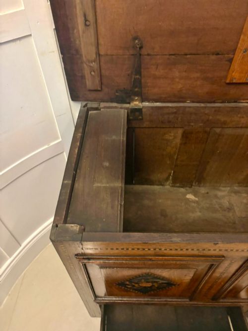 fig 1. A seventeenth-century oak mule chest with three rectangular panelled sections containing central diamond floral marquetry inlays positioned above two base drawers.
