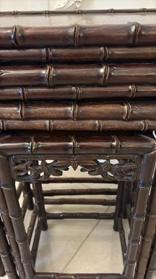 fig 1. A set of four dark brown carved hardwood nesting tables featuring faux bamboo turnings and openwork carved aprons.