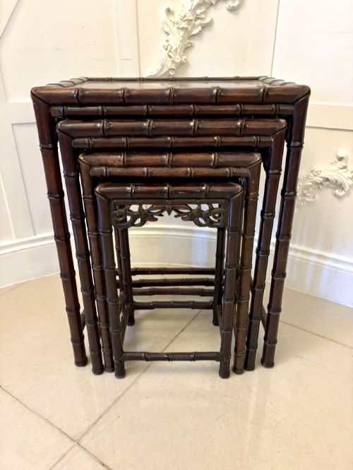 fig 2. A set of four dark brown carved hardwood nesting tables featuring faux bamboo turnings and openwork carved aprons.