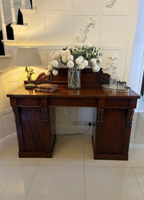 fig 1. A Victorian mahogany pedestal sideboard featuring a raised backboard with carved scrollwork and two flanking pedestal cupboards.