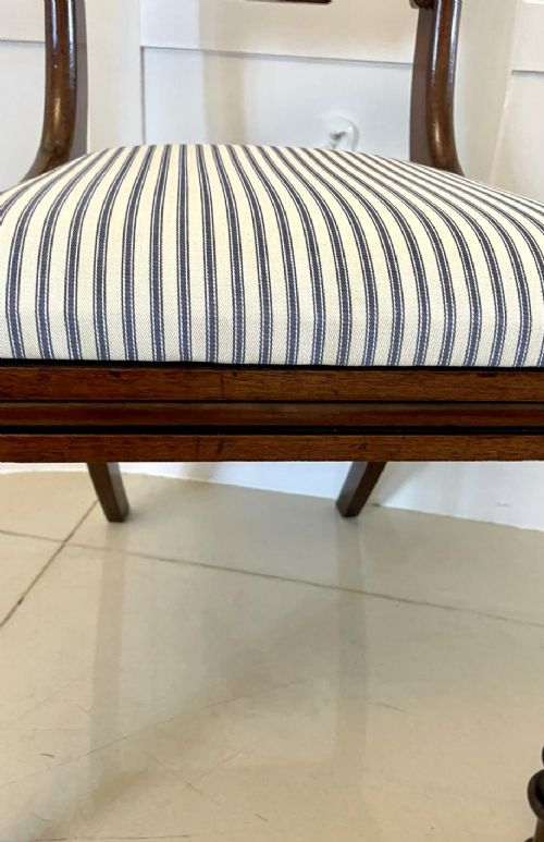 A set of four antique mahogany dining chairs featuring carved scroll top rails, turned front legs, and blue and white striped upholstered seats. View V