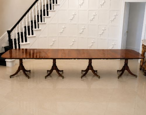 fig 3. An exceptionally long mahogany banquet dining table supported on four turned pedestals with splayed legs and brass castors.