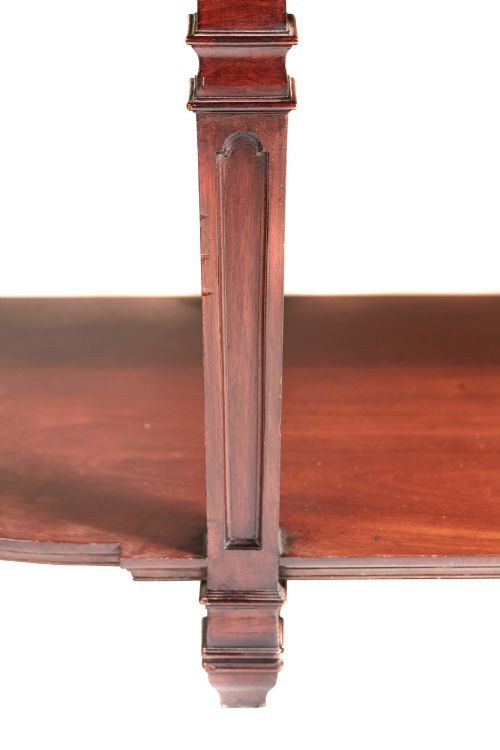 fig 4. A Victorian mahogany breakfront display cabinet with astragal glazed doors, open side shelves, and a swan-neck pediment topped with an urn finial.
