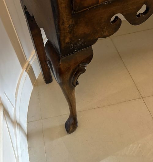 fig 3. A dark brown oak Georgian style dresser base featuring three drawers with brass drop handles, a decorative scalloped apron, and front cabriole legs.