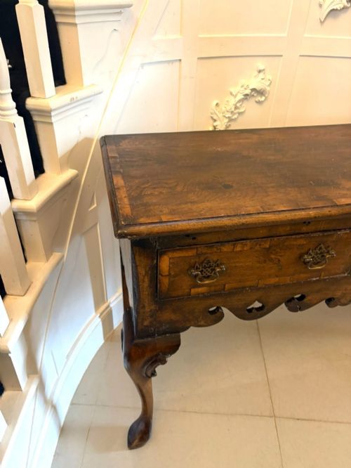fig 4. A dark brown oak Georgian style dresser base featuring three drawers with brass drop handles, a decorative scalloped apron, and front cabriole legs.