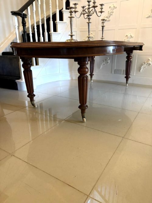 fig 2. An antique Victorian oval mahogany dining table featuring a wind-out extending mechanism, fluted turned legs, and ceramic castors.