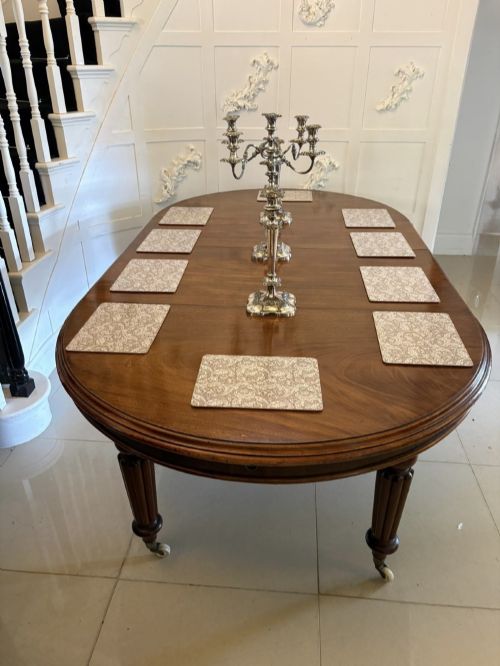 fig 3. An antique Victorian oval mahogany dining table featuring a wind-out extending mechanism, fluted turned legs, and ceramic castors.