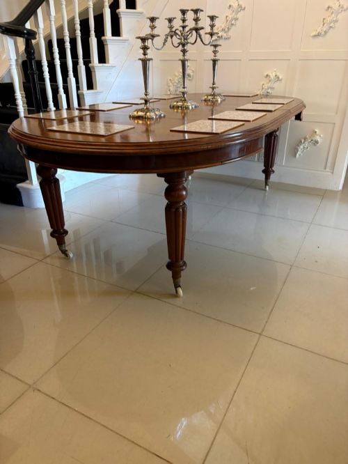 fig 4. An antique Victorian oval mahogany dining table featuring a wind-out extending mechanism, fluted turned legs, and ceramic castors.