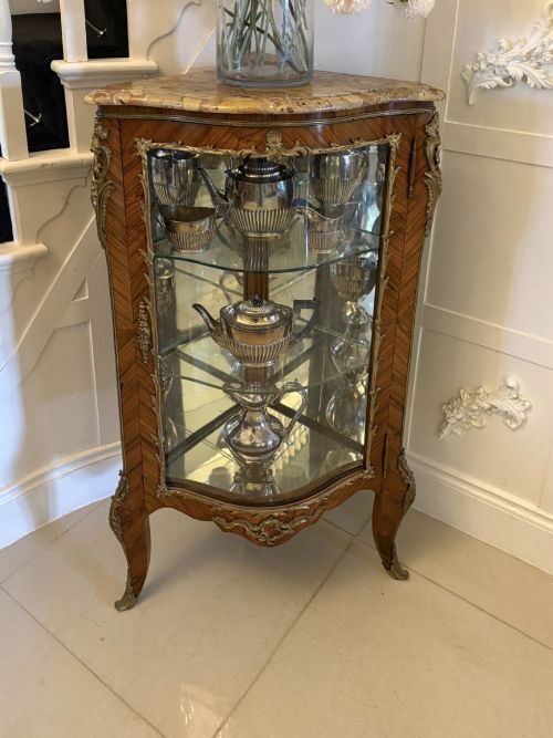 fig 1. An antique French serpentine corner display cabinet crafted from kingwood with a marble top, curved glass door, internal glass shelves, and gilded ormolu mounts.